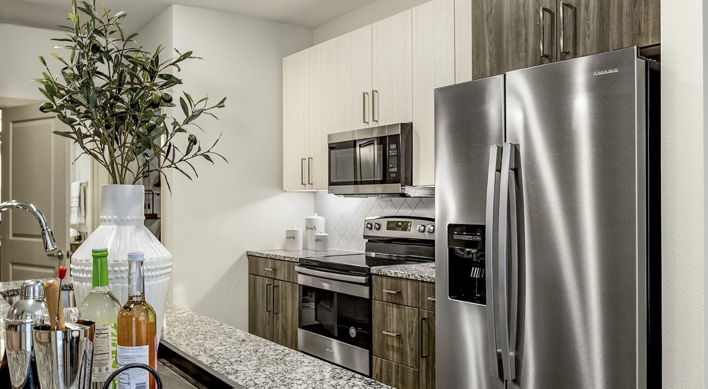 7100 Uvalde Road, Unit 1104 Houston, TX 77049 - Photo 4 of 28 a kitchen with stainless steel appliances a refrigerator a stove and a sink