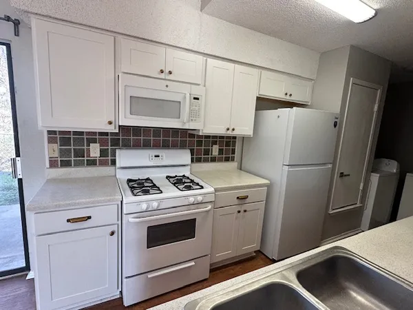 a kitchen with refrigerator a stove a sink and a window