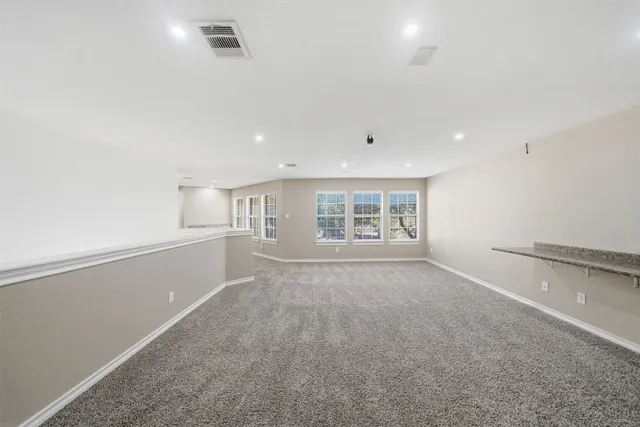 a large white kitchen with kitchen island a sink stainless steel appliances and cabinets