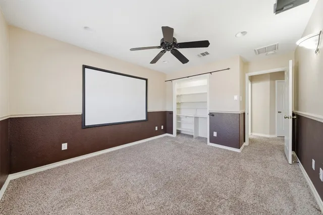 en empty room with windows and ceiling fan