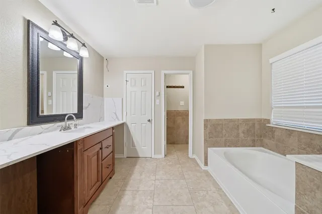 a bathroom with a granite countertop sink and a mirror