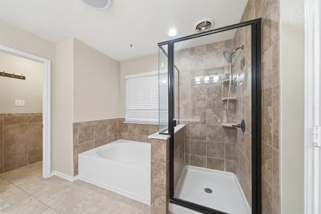 a bathroom with a bathtub a double vanity sink and mirror