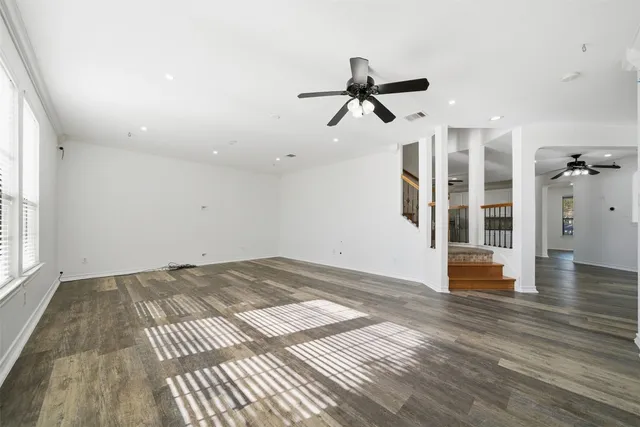 a view of empty room with wooden floor and window
