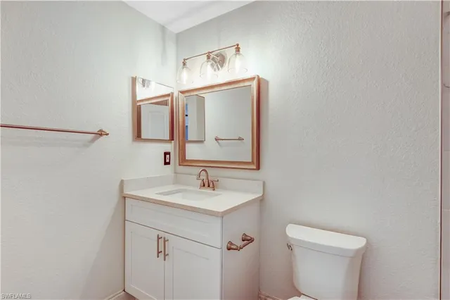 a bathroom with a sink a toilet and mirror