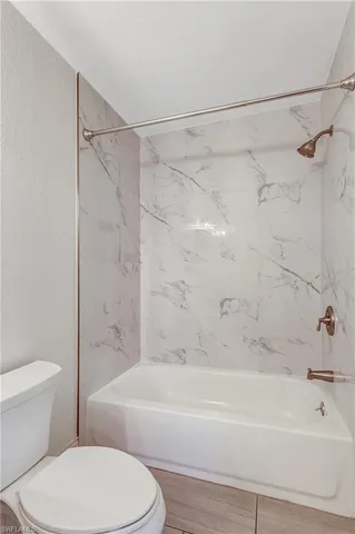 a bathroom with a toilet and a bath tub