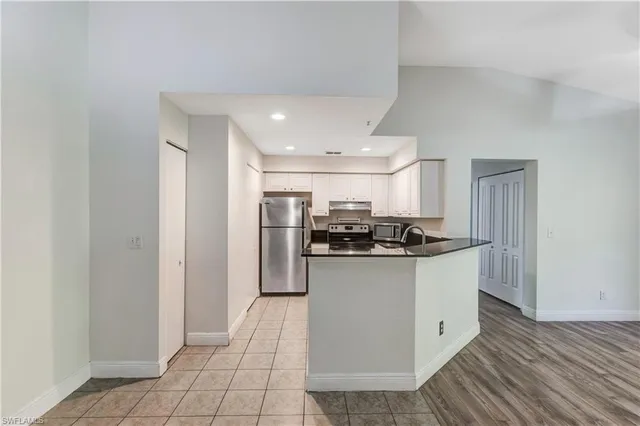 a kitchen with stainless steel appliances granite countertop a sink and a refrigerator