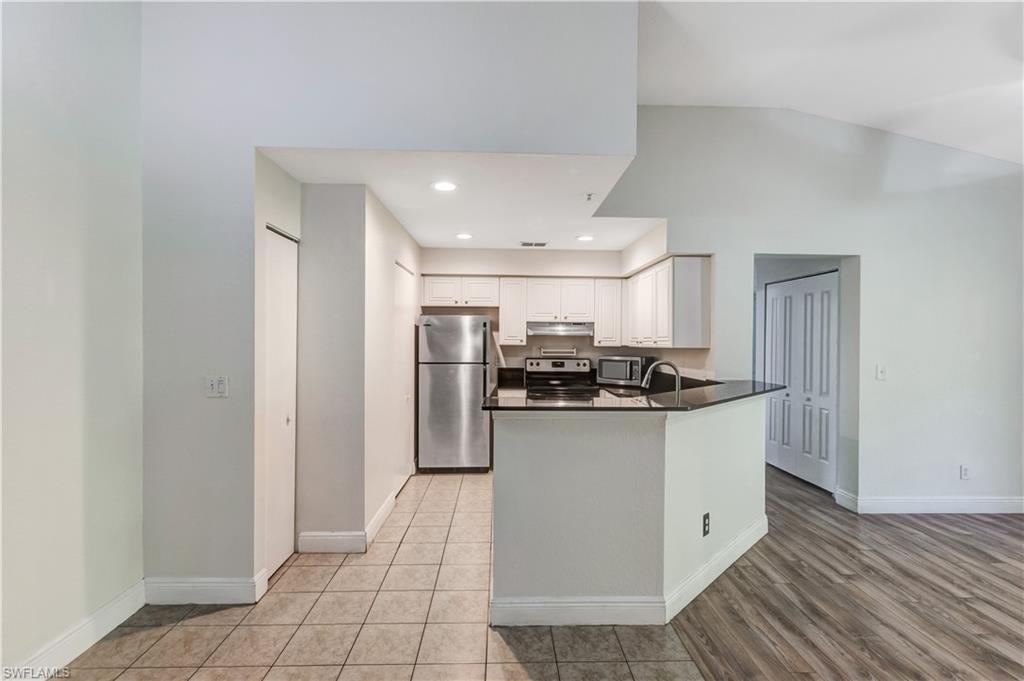 8285 Ibis Club Drive, Unit 807 Naples, FL 34104 - Photo 3 of 42 a kitchen with stainless steel appliances granite countertop a sink and a refrigerator
