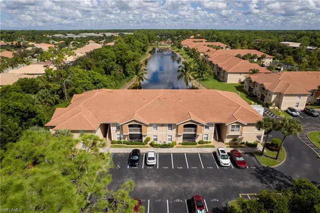 an aerial view of residential houses with outdoor space and trees