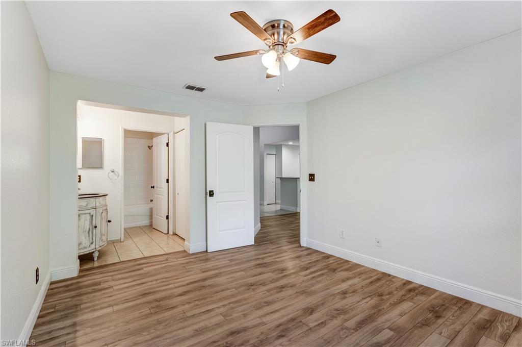 8285 Ibis Club Drive, Unit 807 Naples, FL 34104 - Photo 9 of 42 an empty room with wooden floor and a ceiling fan