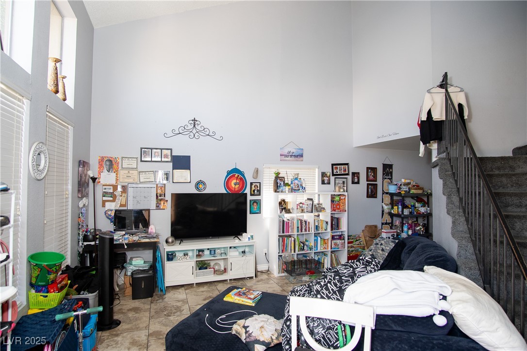 3844 Fitzpatrick Drive Las Vegas, NV 89115 - Photo 5 of 23 Tiled living room featuring a towering ceiling and stairs