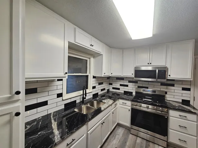 a kitchen with stainless steel appliances granite countertop a stove and a refrigerator