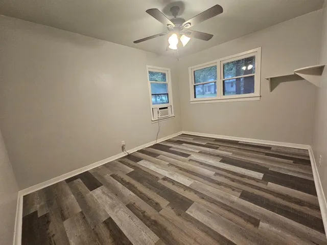 a view of empty room with window and ceiling fan