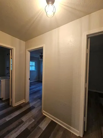 a view of a hallway with wooden floor