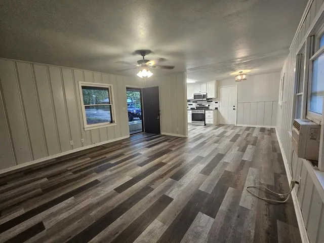 a view of empty room with wooden floor
