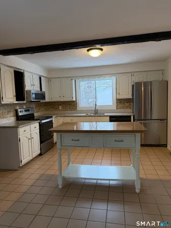 a kitchen with kitchen island granite countertop a stove a sink and a refrigerator