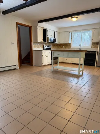 a living room with stainless steel appliances kitchen island granite countertop furniture and a fireplace