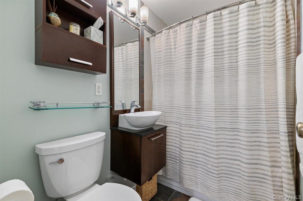 700 Shore Road, Unit 7Y Long Beach, NY 11561 - Photo 17 of 31 Full bath featuring curtained shower, vanity, and dark tile patterned floors