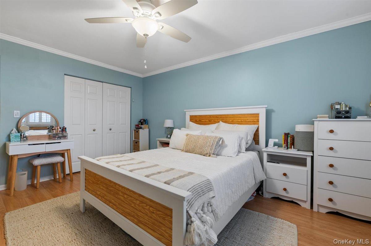 700 Shore Road, Unit 7Y Long Beach, NY 11561 - Photo 18 of 31 Bedroom with crown molding, a ceiling fan, a closet, and light wood finished floors
