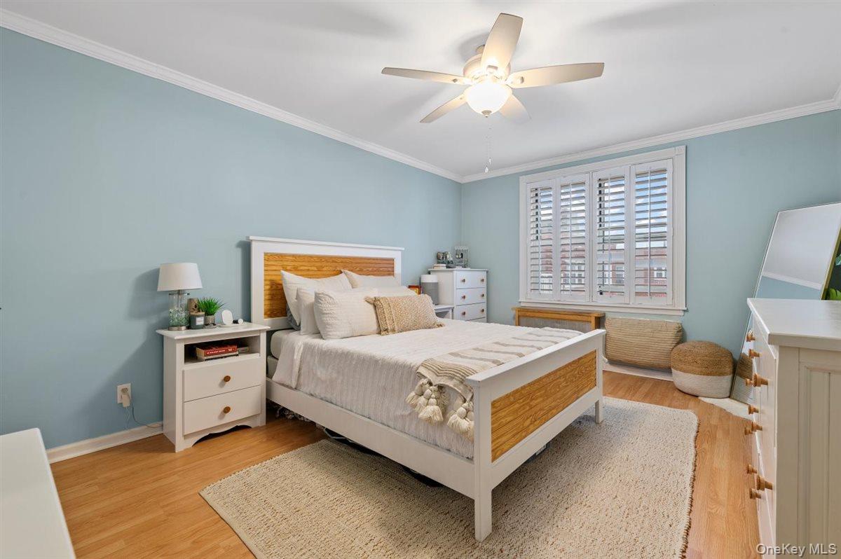 700 Shore Road, Unit 7Y Long Beach, NY 11561 - Photo 20 of 31 Bedroom with ornamental molding, a ceiling fan, and light wood-style flooring