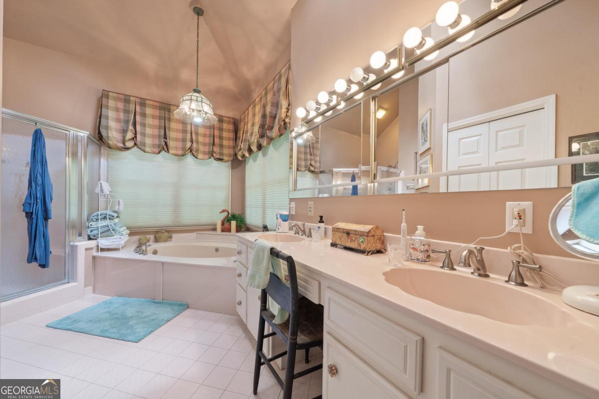 1031 Old Still Road Greensboro, GA 30642 - Photo 36 of 73 a spacious bathroom with a sink a large mirror and a bathtub