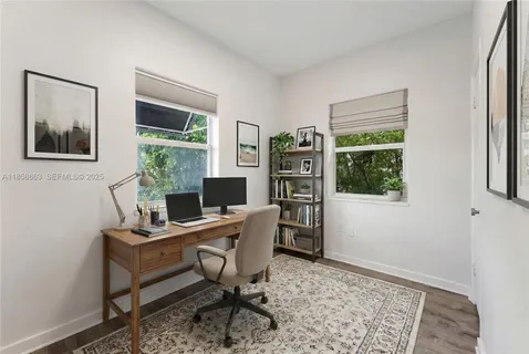 a view of a workspace with furniture and a window