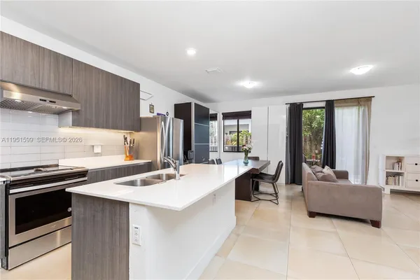 a kitchen with a stove a refrigerator and a sink