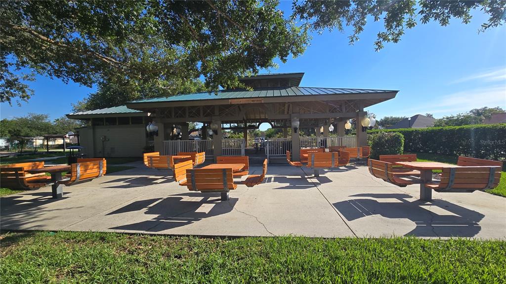 2009 Meadow Rue Court Trinity, FL 34655 - Photo 19 of 21 a view of a patio with table and chairs potted plants and a large tree