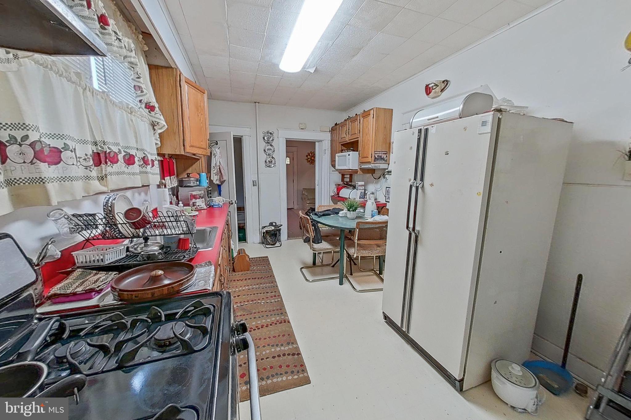 2803 Ruscombe Lane Baltimore, MD 21215 - Photo 11 of 28 a kitchen with stainless steel appliances a stove a refrigerator and a refrigerator