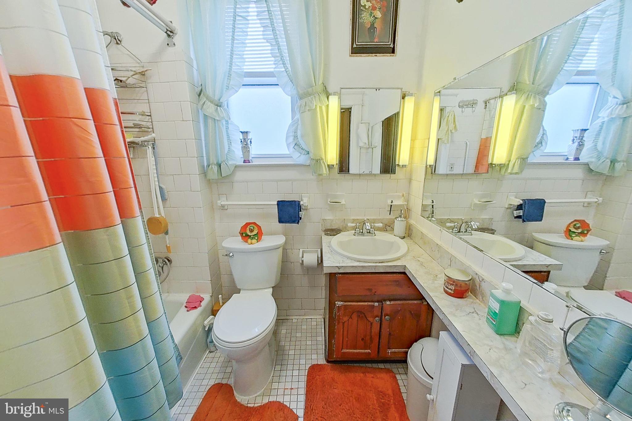 2803 Ruscombe Lane Baltimore, MD 21215 - Photo 17 of 28 a bathroom with a sink a toilet and shower curtain