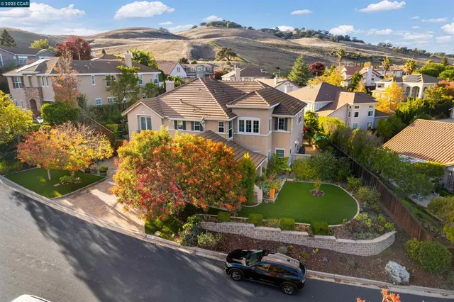 an aerial view of a house with a garden and lake view