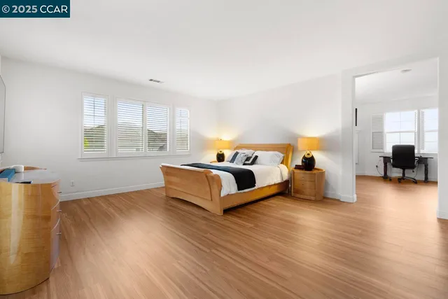 a view of a hallway with wooden floor and a potted plant