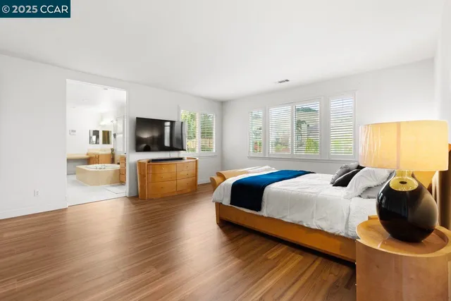 a spacious bathroom with a double vanity sink mirror and bathtub