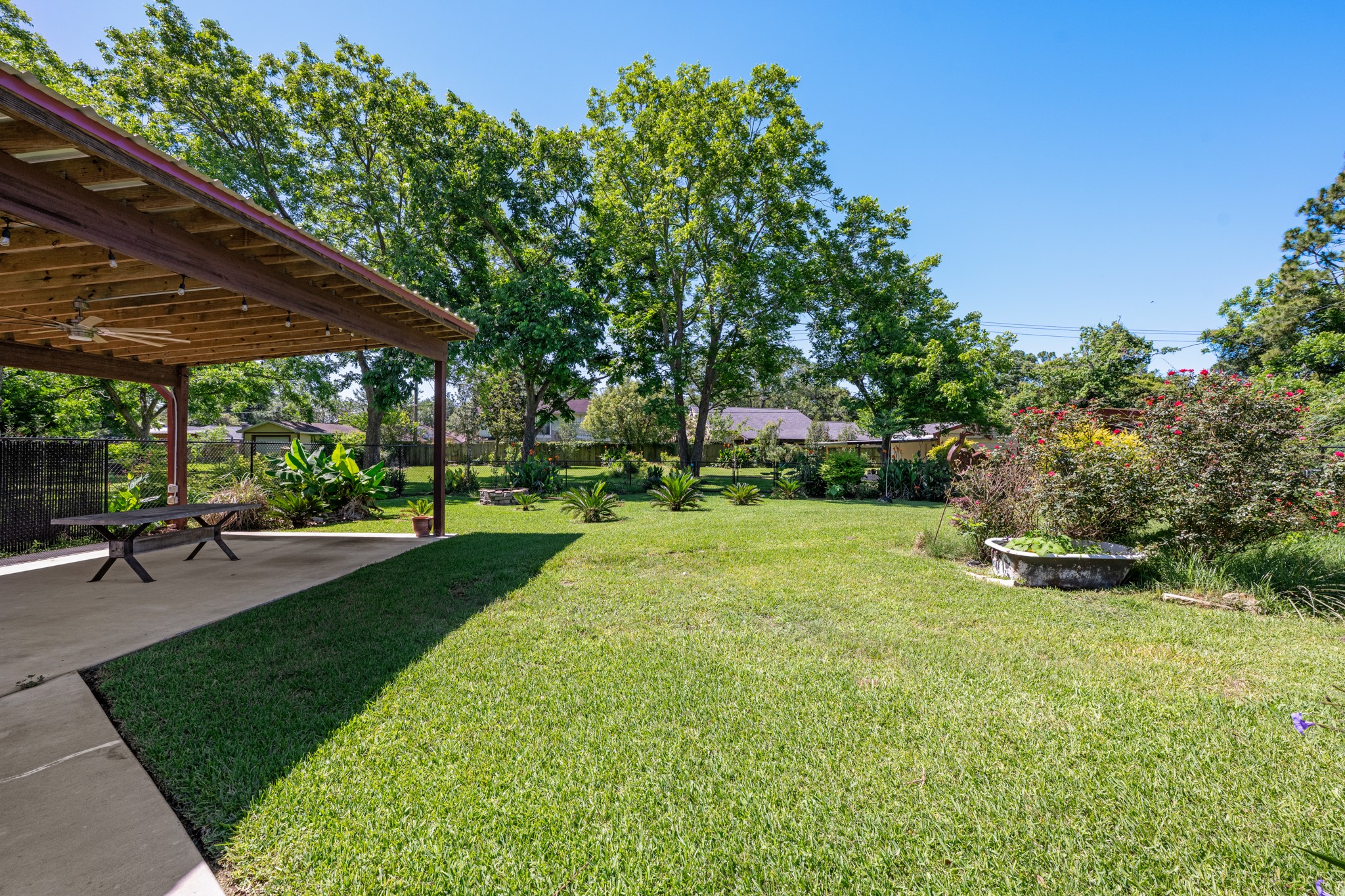 616 Cannan Drive Angleton, TX 77515 - Photo 31 of 49 Spacious backyard offers a park-like setting with lush lawn, mature shade trees, and thoughtfully landscaped garden beds. The expansive outdoor space provides endless opportunities for recreation, gardening, and entertaining while enjoying the privacy of the oversized lot.