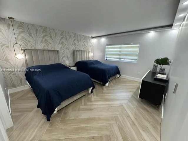 a bedroom with two beds and a potted plant