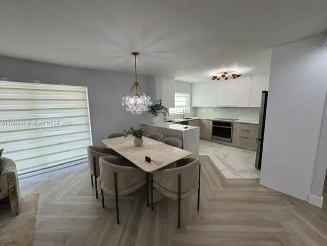 a dining room with furniture a chandelier and wooden floor