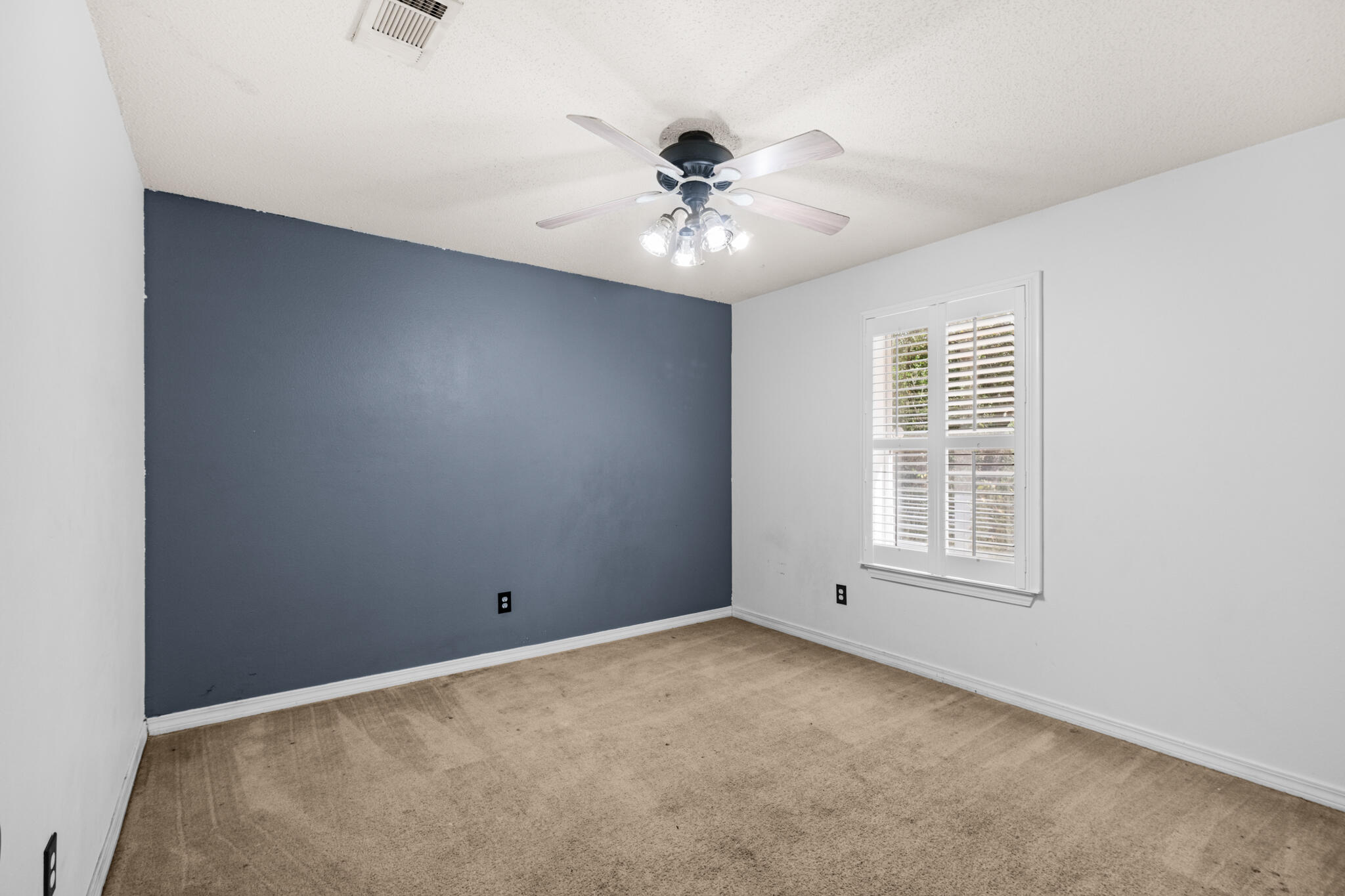 233 Lustan Drive Crestview, FL 32536 - Photo 19 of 22 an empty room with a chandelier fan and windows
