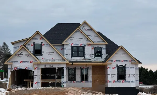 a view of a big house with large windows and a yard
