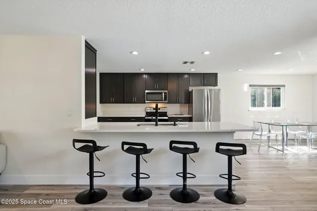 a kitchen with stainless steel appliances a sink a stove a refrigerator and cabinets