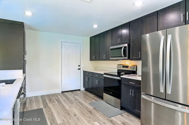 a kitchen with granite countertop stainless steel appliances cabinets a sink and a counter space