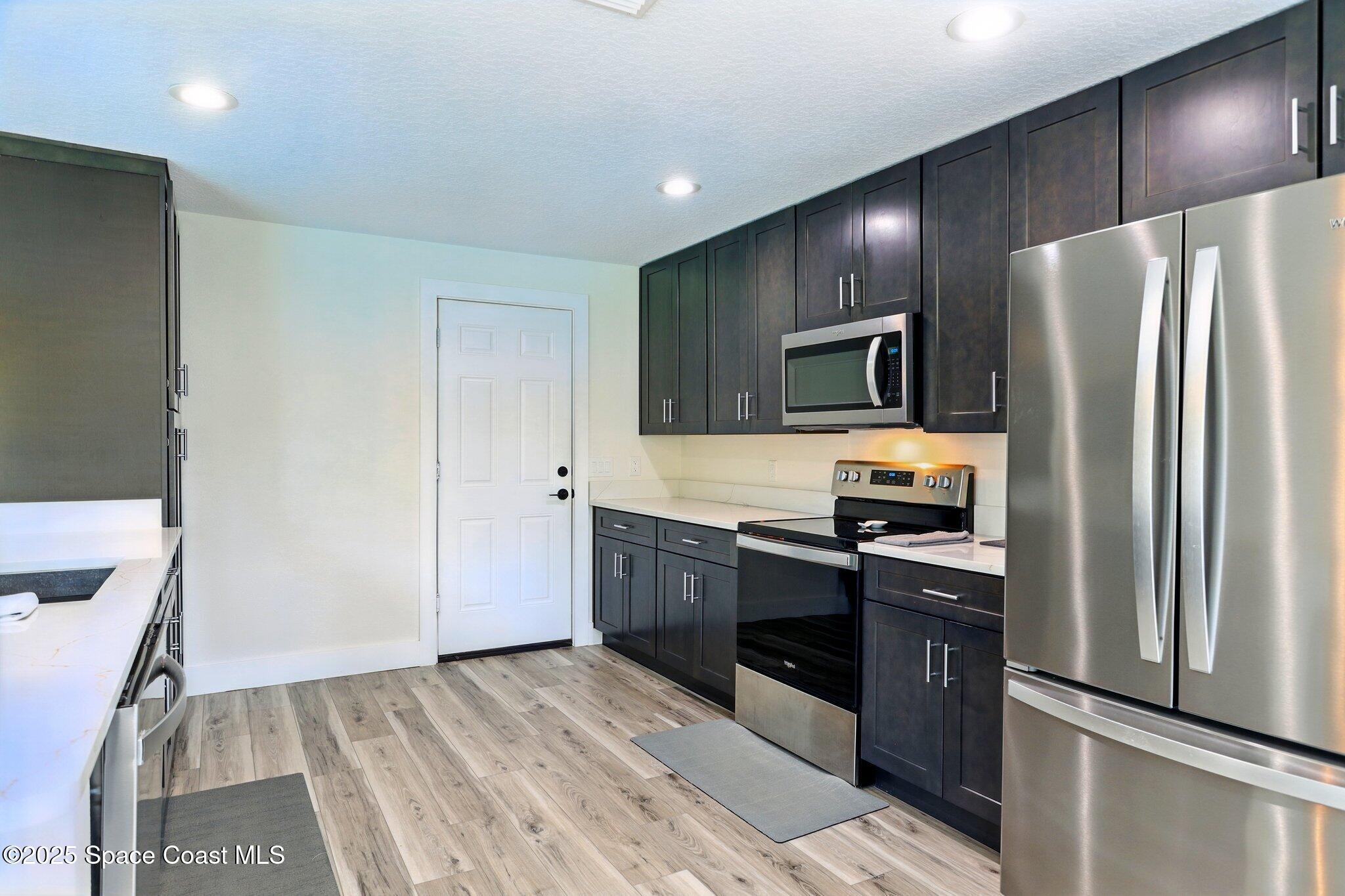 135 Richland Avenue Merritt Island, FL 32953 - Photo 16 of 24 a kitchen with granite countertop stainless steel appliances cabinets a sink and a counter space