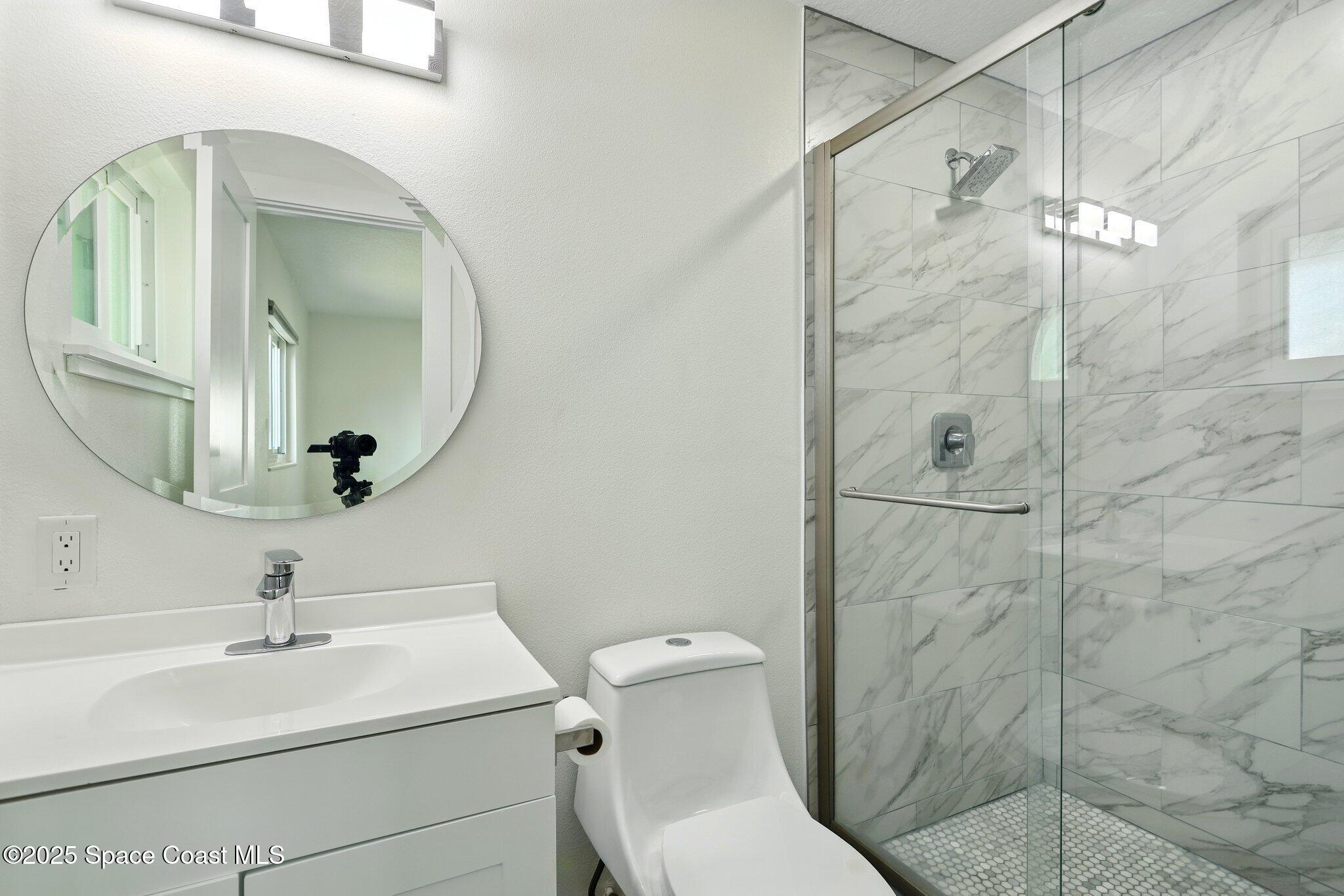 135 Richland Avenue Merritt Island, FL 32953 - Photo 21 of 24 a bathroom with a toilet sink vanity granite and shower