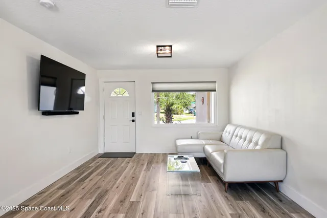 a living room with furniture and a wooden floor