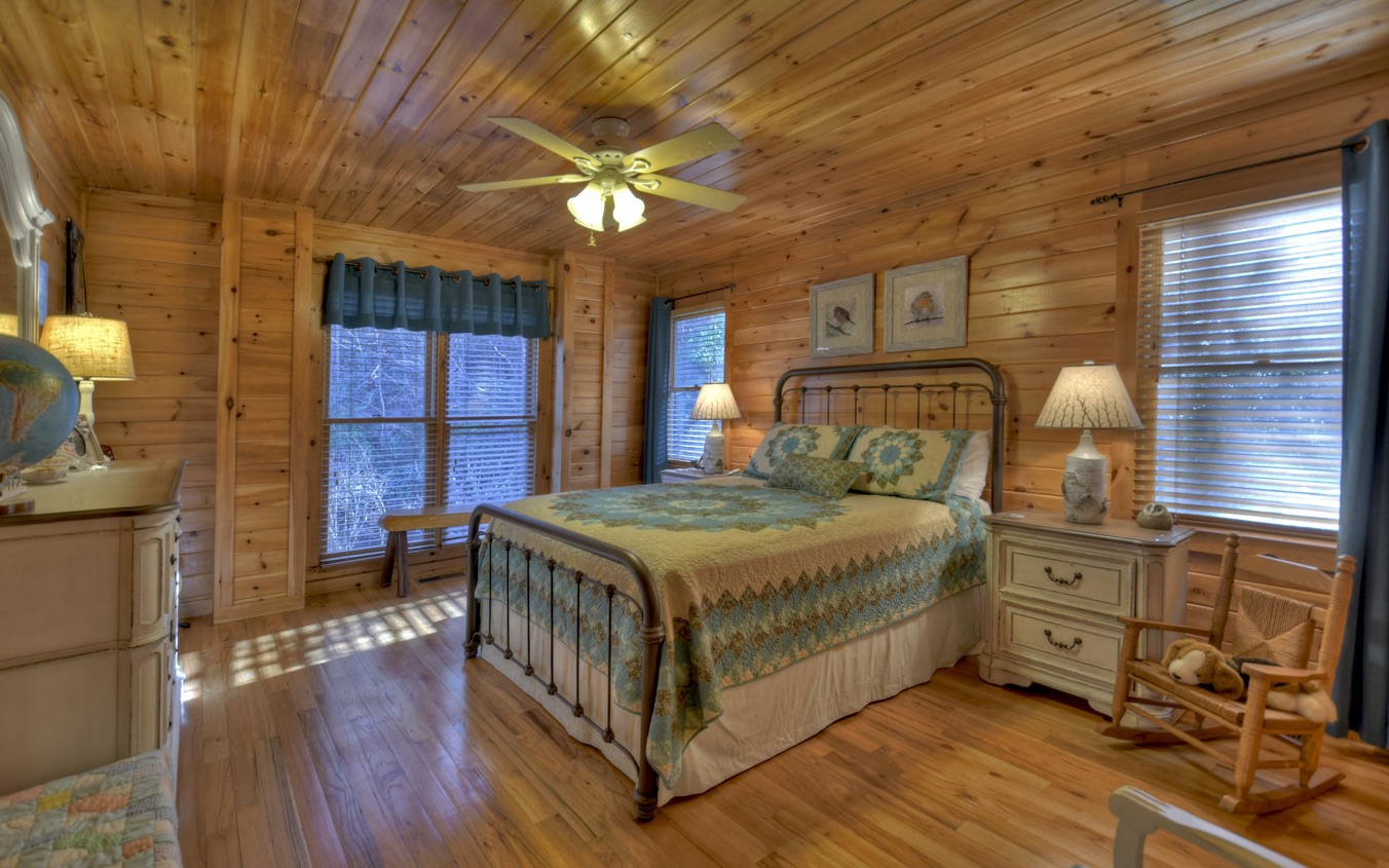 126 Stillwater Road Blue Ridge, GA 30513 - Photo 33 of 62 a bedroom with a bed and a chandelier