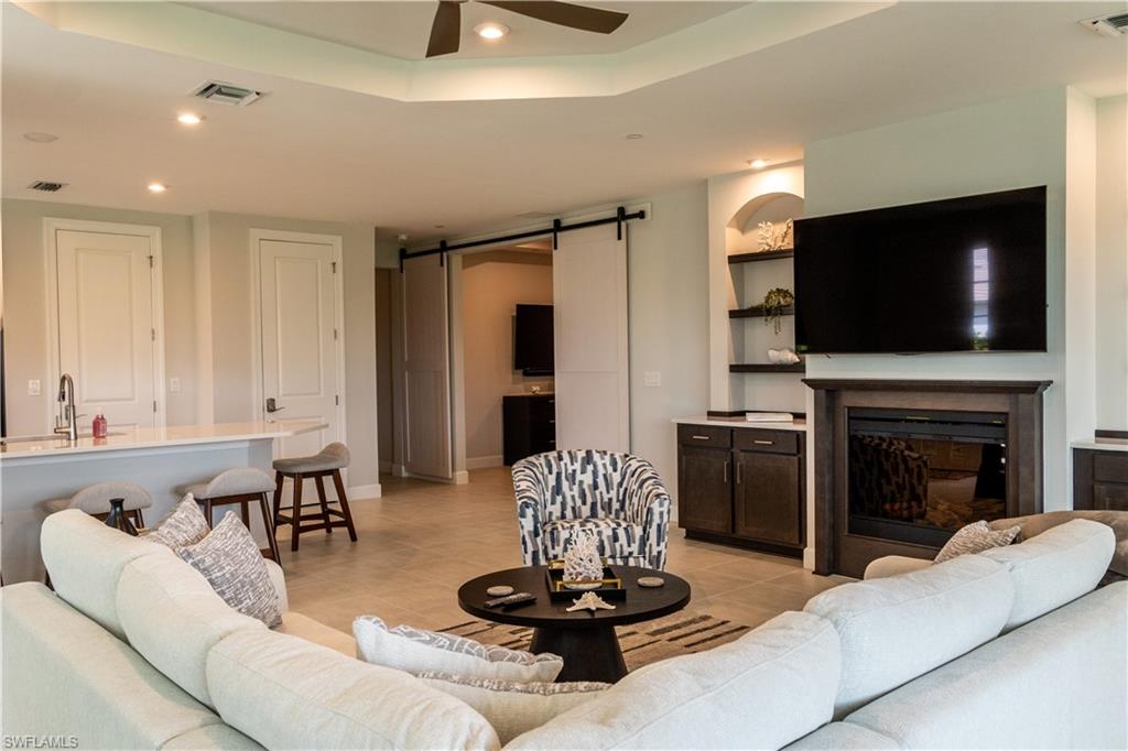 15335 Lucerna Street, Unit 104 Naples, FL 34114 - Photo 11 of 44 a living room with furniture and a flat screen tv