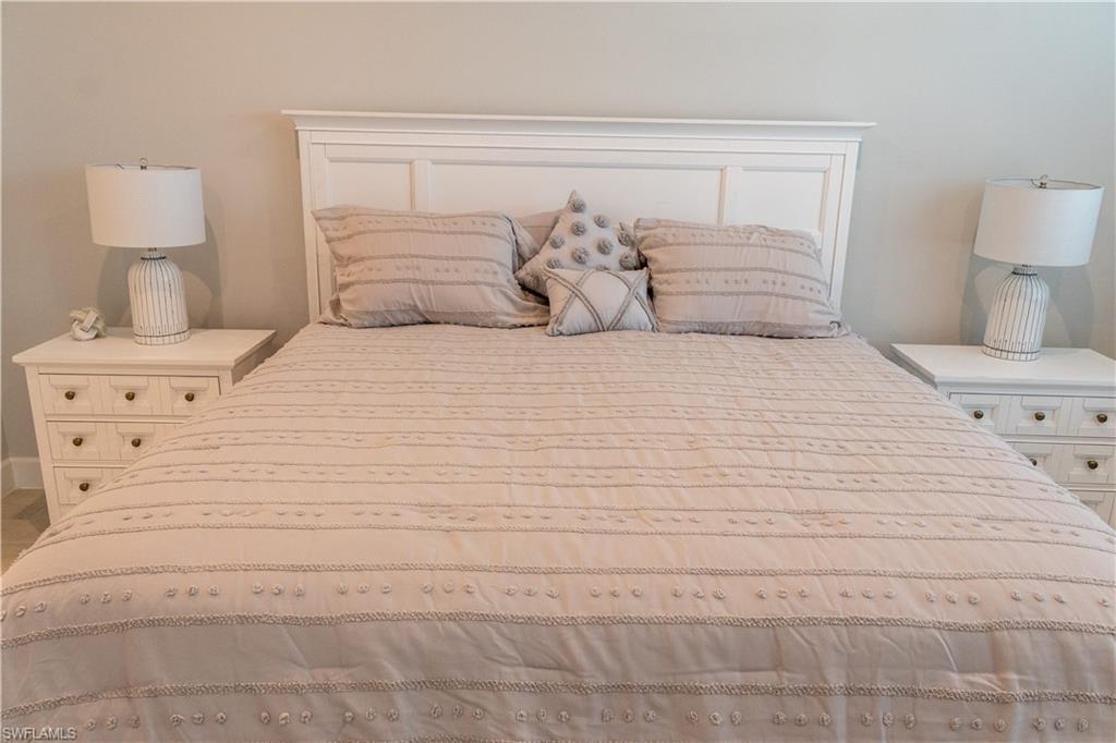 15335 Lucerna Street, Unit 104 Naples, FL 34114 - Photo 12 of 44 a bedroom with a bed and a lamp