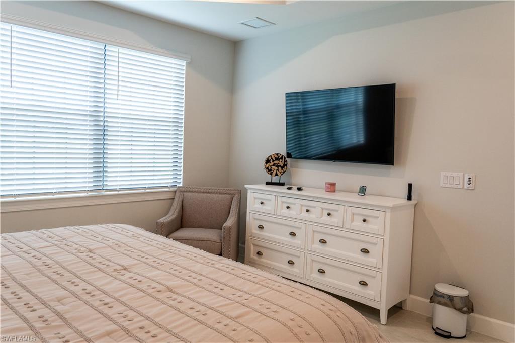 15335 Lucerna Street, Unit 104 Naples, FL 34114 - Photo 14 of 44 a bedroom with a bed and a flat screen tv