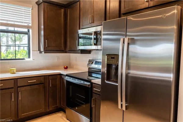 a kitchen with a refrigerator sink and cabinets