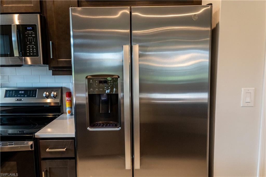 15335 Lucerna Street, Unit 104 Naples, FL 34114 - Photo 23 of 44 a kitchen with a refrigerator and a stove
