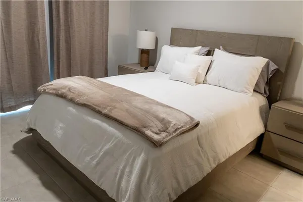 a large bed sitting in a bedroom next to a window