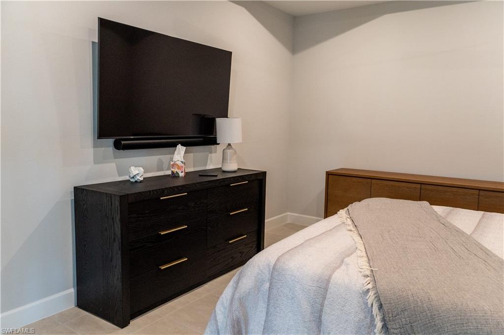15335 Lucerna Street, Unit 104 Naples, FL 34114 - Photo 31 of 44 a bedroom with a bed and a flat screen tv
